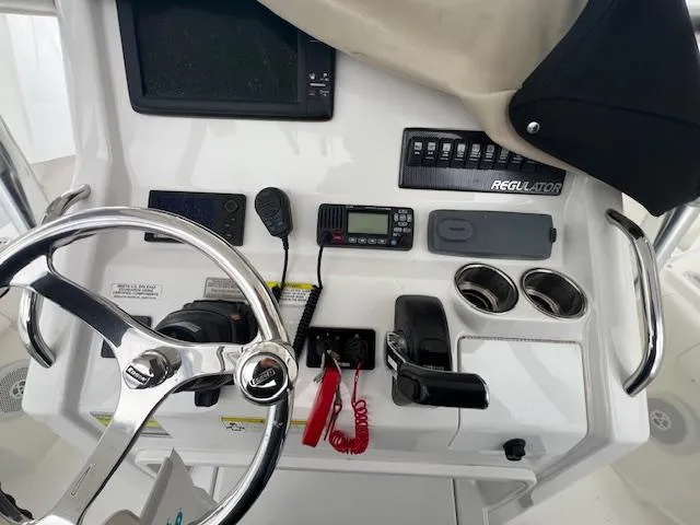 Slide: The Image of 2015 Regulator 23 Forward Seating boat dashboard with steering wheel, controls, and electronics. - 21