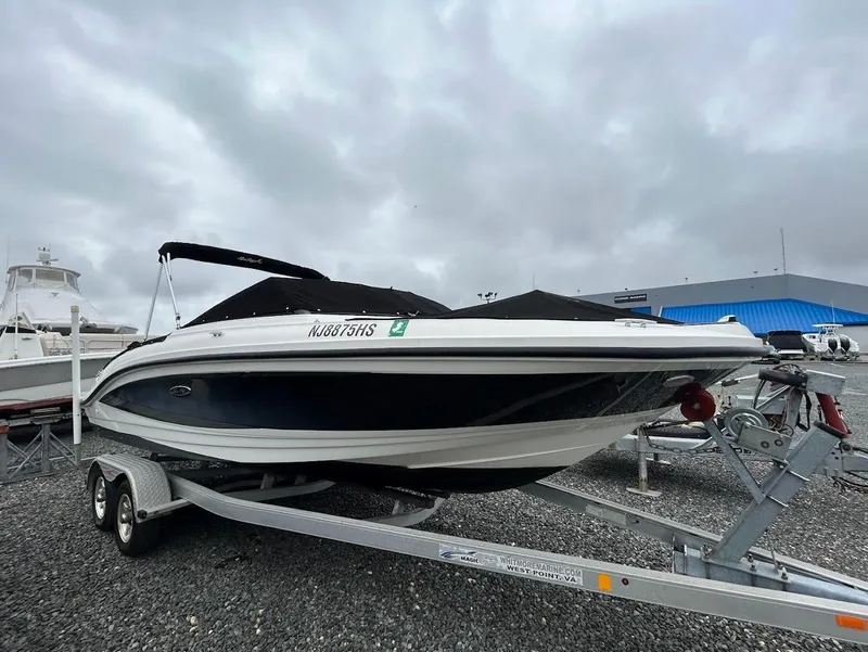The Image of 2016 Sea Ray SPX 210 boat on trailer, covered, parked outdoors under cloudy sky. - 0
