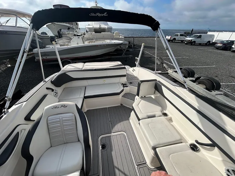 Slide: The Image of 2016 Sea Ray SPX 210 boat interior with seating and canopy, docked near other boats. - 4