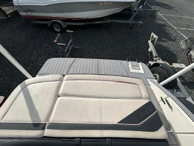 Slide: The Image of 2016 Sea Ray SPX 210 boat with cushioned seating and swim platform, parked on gravel. - 8