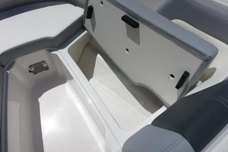 Slide: The Image of 2025 Chaparral 23 SSi OB boat storage compartment with open lid, showcasing spacious interior. - 18