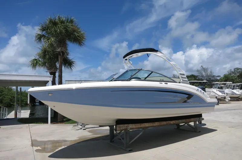 Slide: The Image of 2025 Chaparral 23 SSi OB boat on display under a clear blue sky. - 2