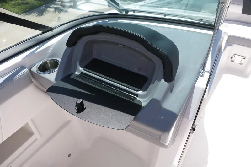 Slide: The Image of 2025 Chaparral 23 SSi OB boat dashboard with storage compartment and cup holder. - 24
