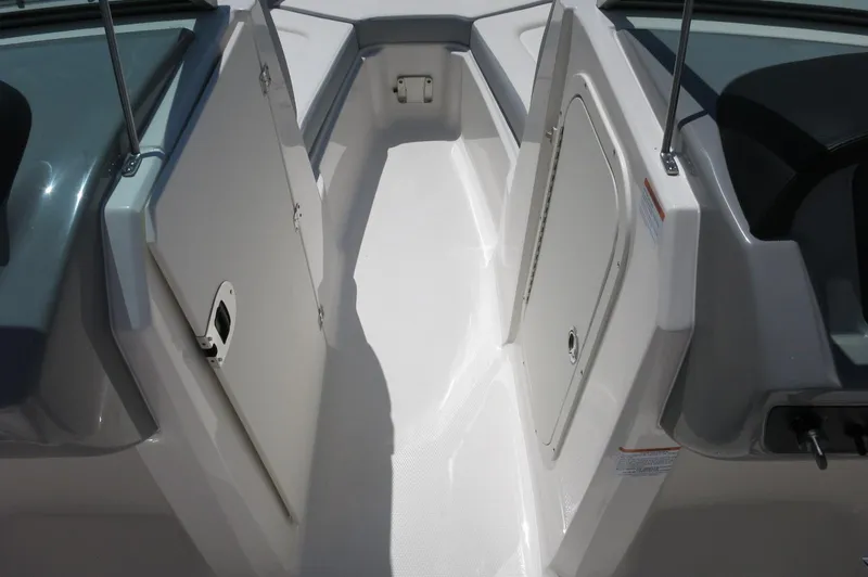 Slide: The Image of 2025 Chaparral 23 SSi OB boat interior with storage compartments and sleek design. - 25