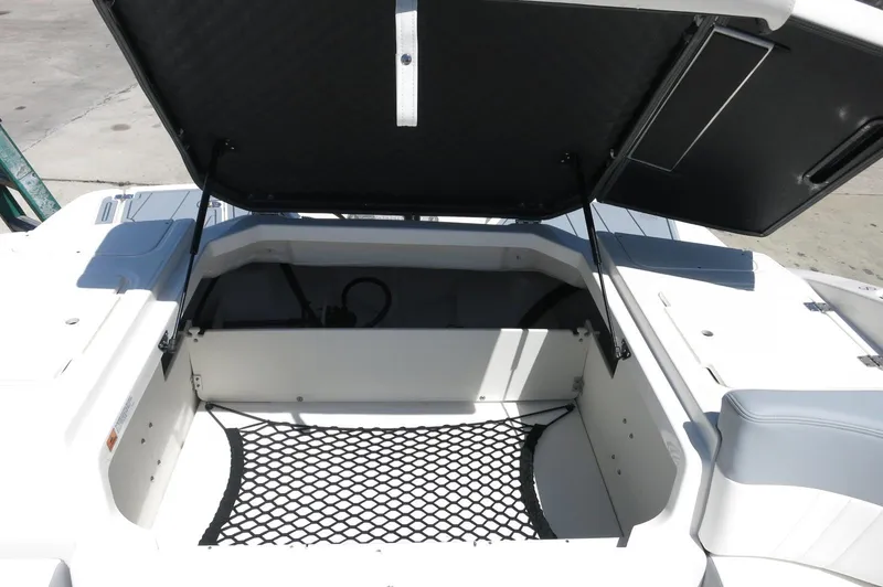 Slide: The Image of 2025 Chaparral 23 SSi OB boat storage compartment with open lid and netting. - 31