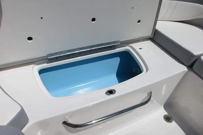 Slide: The Image of 2025 Chaparral 23 SSi OB boat storage compartment with open lid and blue interior. - 37