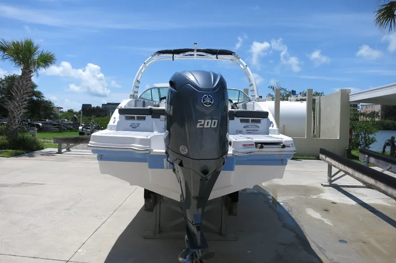 Slide: The Image of 2025 Chaparral 23 SSi OB boat with Yamaha 200 outboard motor, docked under clear blue sky. - 4