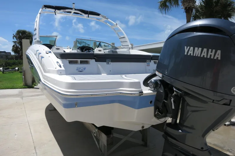 Slide: The Image of 2025 Chaparral 23 SSi OB boat with Yamaha outboard motor, docked under clear blue sky. - 6