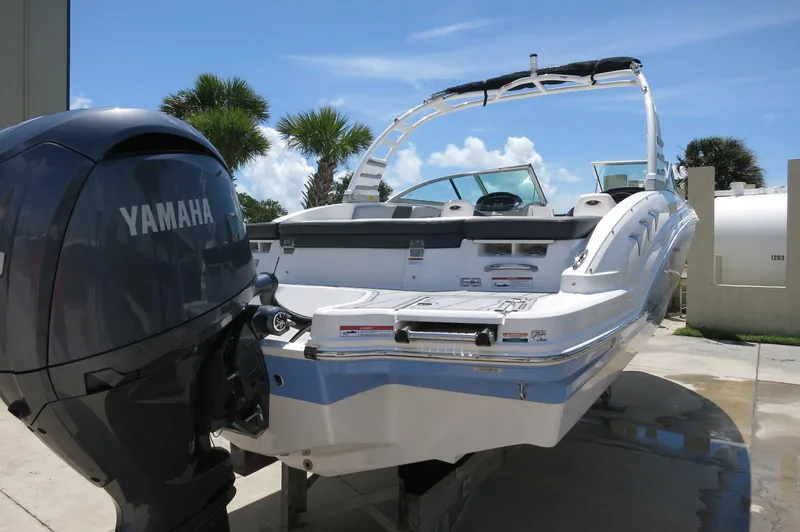 Slide: The Image of 2025 Chaparral 23 SSi OB boat with Yamaha outboard motor, parked outdoors. - 7