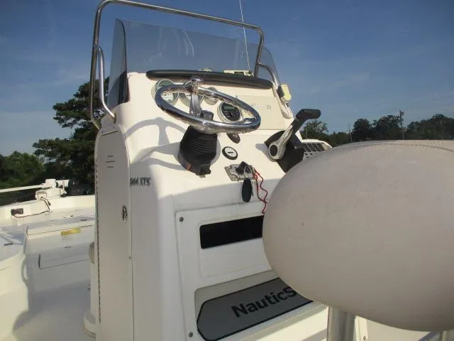 Slide: The Image of 2014 NauticStar 244 XTS boat console with steering wheel and controls under clear blue sky. - 4