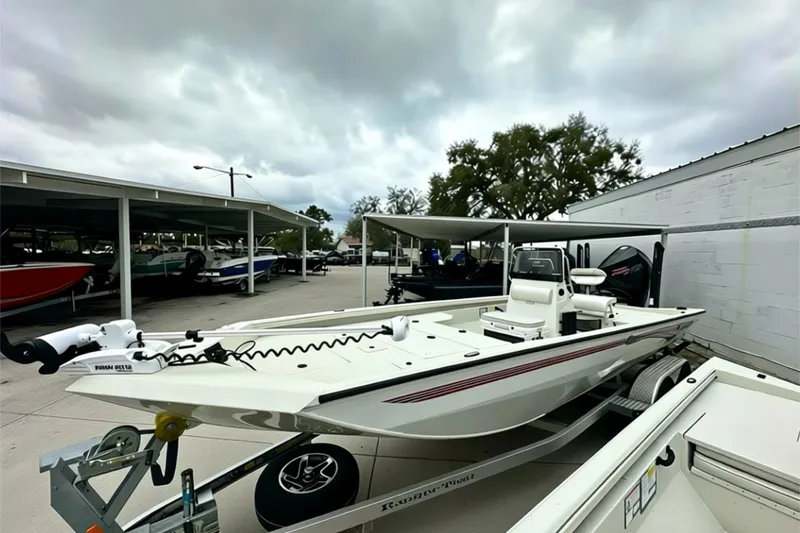Slide: The Image of 2025 Ranger RB210 boat on trailer under cloudy sky at dealership. - 11