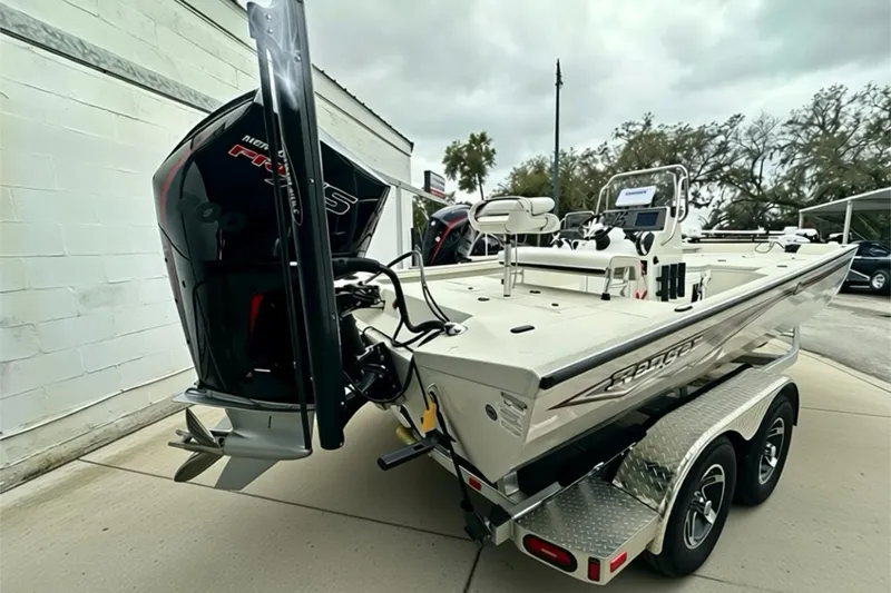 Slide: The Image of 2025 Ranger RB210 boat on trailer, featuring powerful outboard motor, parked outdoors. - 14