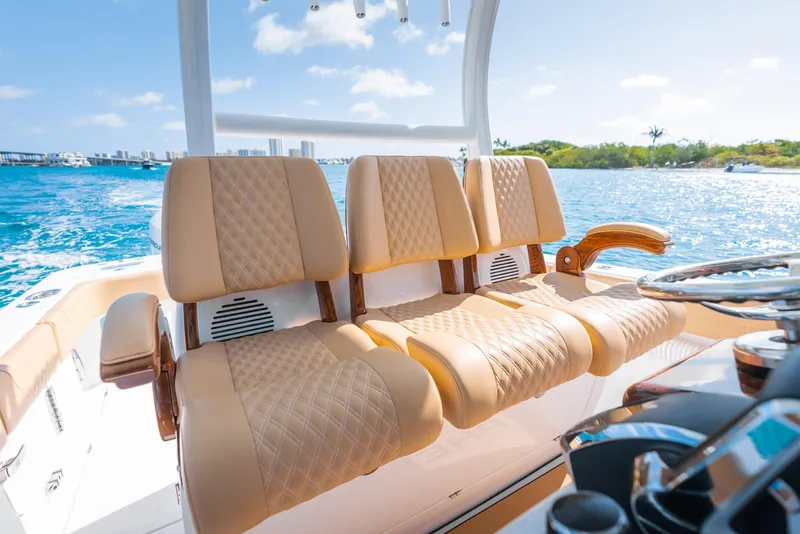 Slide: The Image of Luxurious seating on 2026 Phenom 34 Center Console boat, cruising on clear blue waters. - 9
