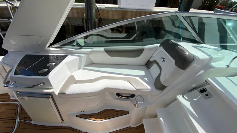 Slide: The Image of 2015 Monterey 295 Sport Yacht interior with white seating and kitchenette area. - 12
