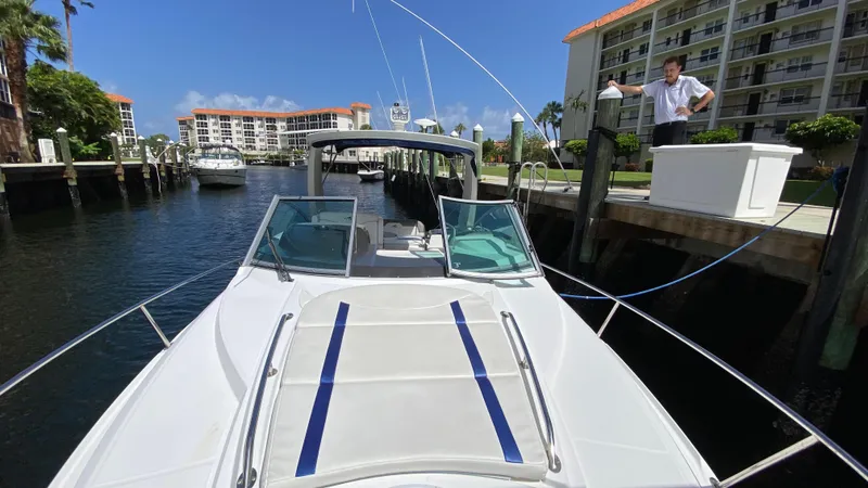 Slide: The Image of 2015 Monterey 295 Sport Yacht docked near waterfront buildings under clear blue sky. - 17