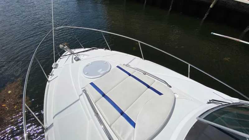Slide: The Image of 2015 Monterey 295 Sport Yacht bow with sun pad, docked on calm water. - 21