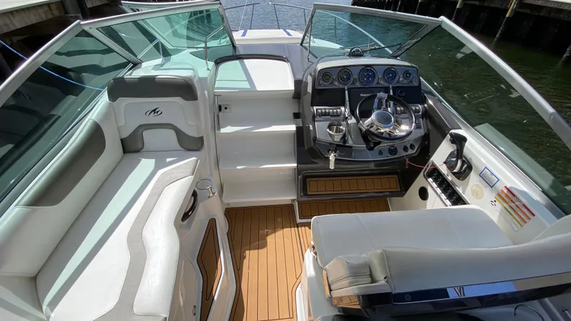 Slide: The Image of 2015 Monterey 295 Sport Yacht interior with helm, seating, and wood flooring. - 22