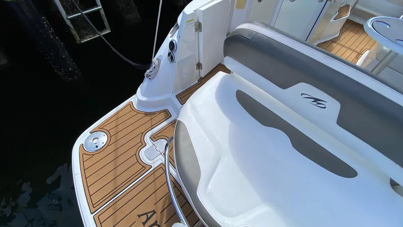 Slide: The Image of 2015 Monterey 295 Sport Yacht with teak deck and seating area, docked by the water. - 3
