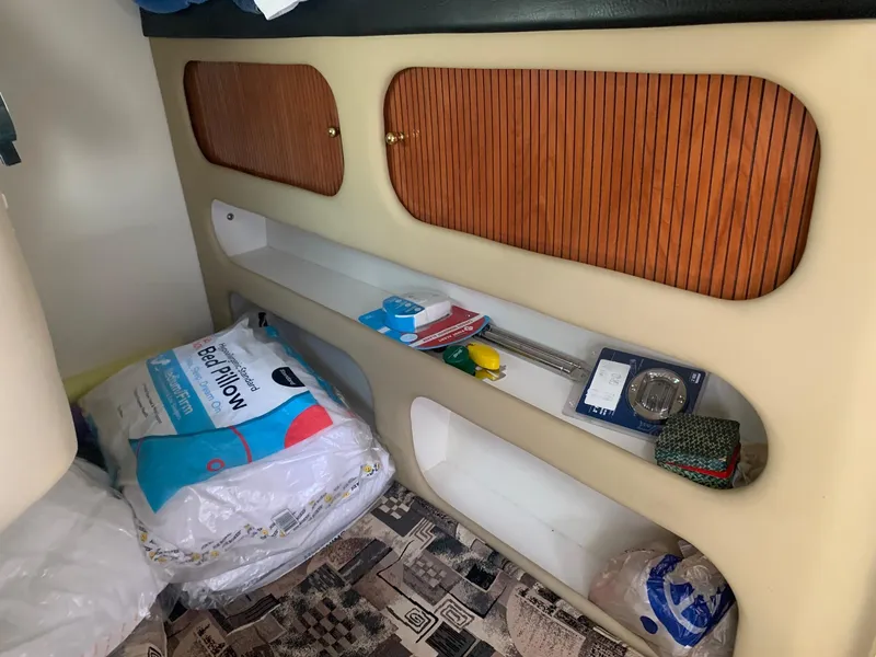 Slide: The Image of Interior storage area of a 2003 Rinker Fiesta Vee 270 boat with shelves and pillows. - 11