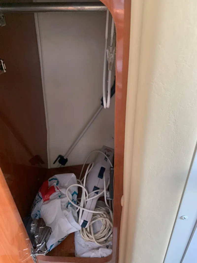 Slide: The Image of Storage compartment in a 2003 Rinker Fiesta Vee 270 boat, containing various items. - 13