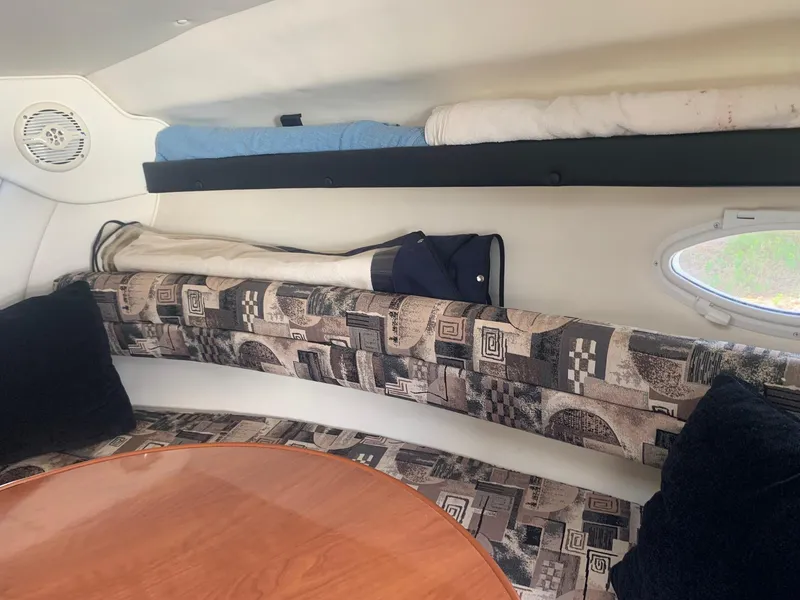 Slide: The Image of Interior of 2003 Rinker Fiesta Vee 270 EC boat with patterned seating and wooden table. - 14