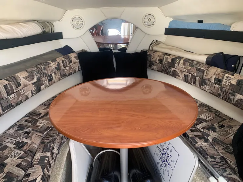 Slide: The Image of Interior of 2003 Rinker Fiesta Vee 270 EC boat with cozy seating and wooden table. - 18