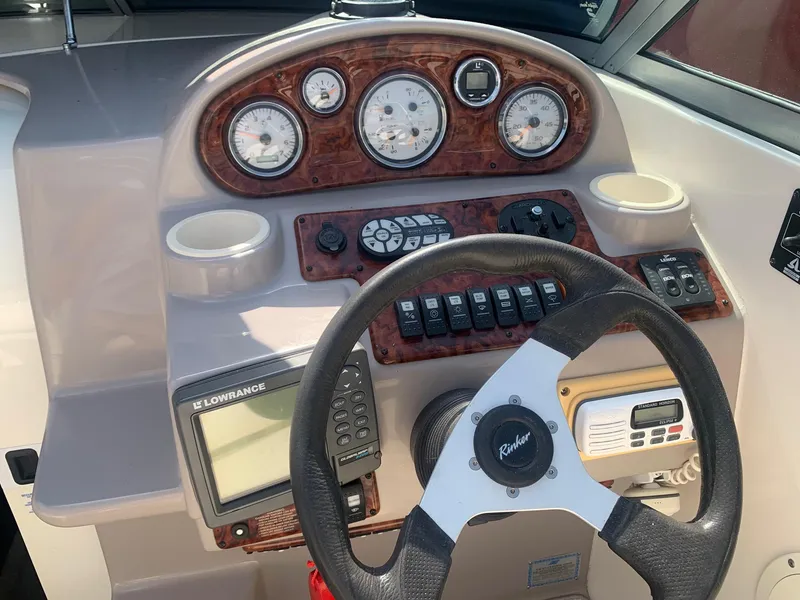 Slide: The Image of 2003 Rinker Fiesta Vee 270 EC boat dashboard with steering wheel and navigation instruments. - 26