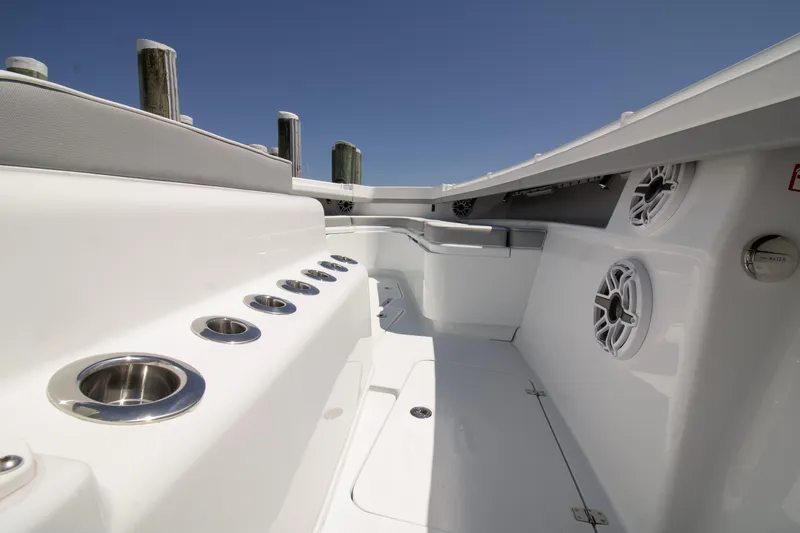 Slide: The Image of 2026 Yellowfin 42 Offshore boat interior with rod holders and speakers, under clear blue sky. - 23