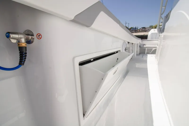 Slide: The Image of 2026 Yellowfin 42 Offshore boat deck with storage compartment and hose connection. - 25