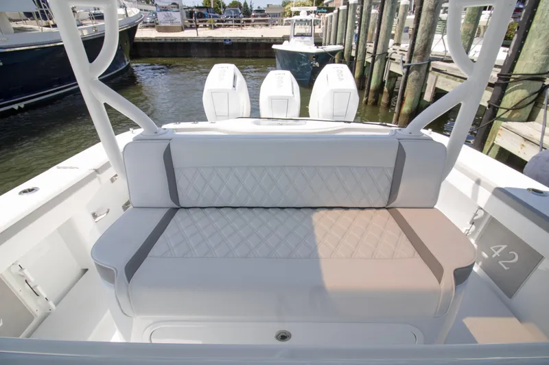 Slide: The Image of 2026 Yellowfin 42 Offshore boat with cushioned seating and triple outboard engines. - 32