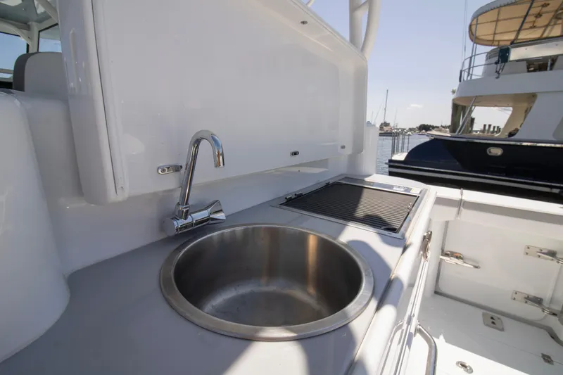 Slide: The Image of 2026 Yellowfin 42 Offshore boat sink and grill area, docked at marina. - 43