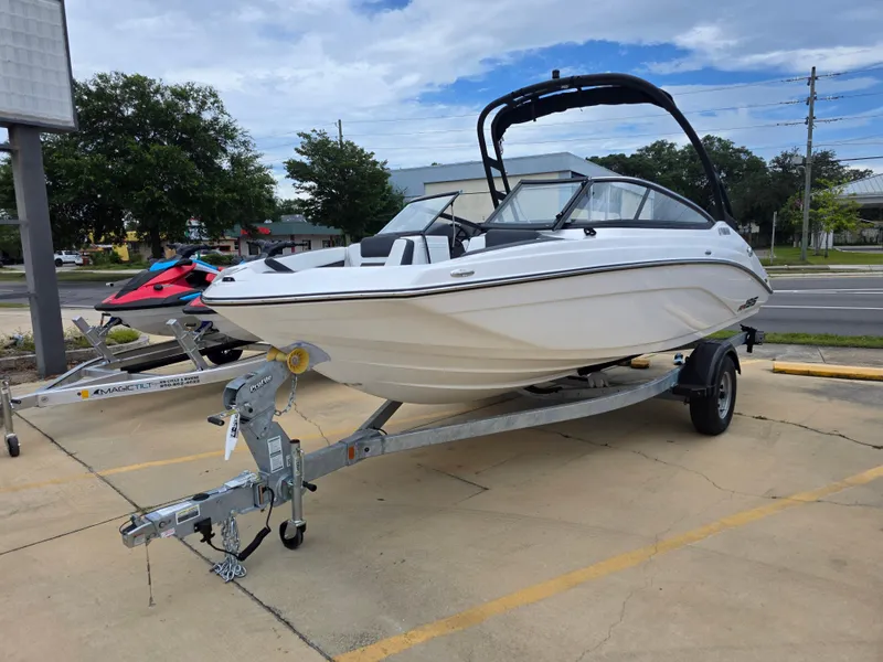 The Image of 2025 Yamaha Boats AR195 on trailer, parked outdoors under cloudy sky. - 1