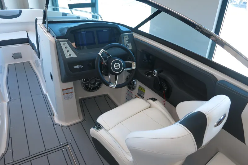 Slide: The Image of 2025 Chaparral 250 OSX boat interior with modern helm and white seating. - 16