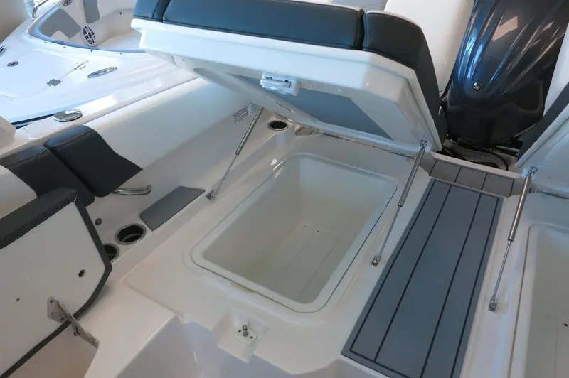 Slide: The Image of 2025 Chaparral 250 OSX boat interior with open storage compartment and seating. - 28