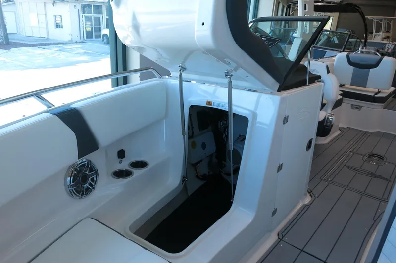 Slide: The Image of 2025 Chaparral 250 OSX boat interior with open storage compartment and seating. - 9
