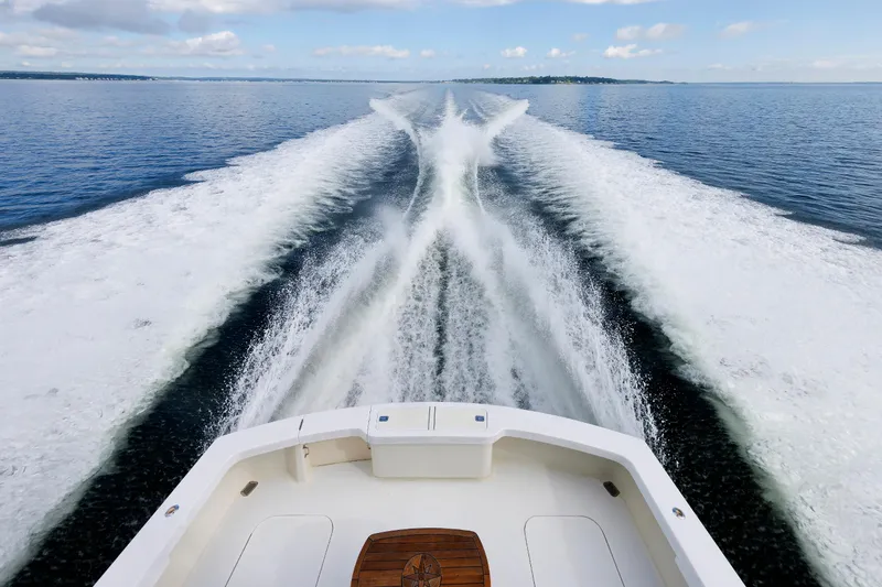 Slide: The Image of Wake trail behind a 2002 Post Convertible 56 yacht on open water. - 13