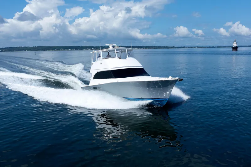 Slide: The Image of A 2002 Post Convertible 56 yacht cruising on calm blue waters under a clear sky. - 16