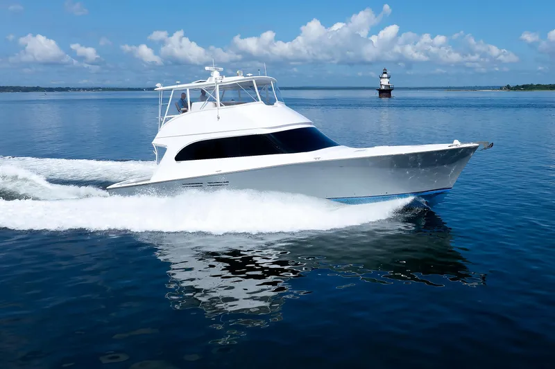 Slide: The Image of 2002 Post Convertible 56 yacht cruising on calm blue waters near a lighthouse. - 17