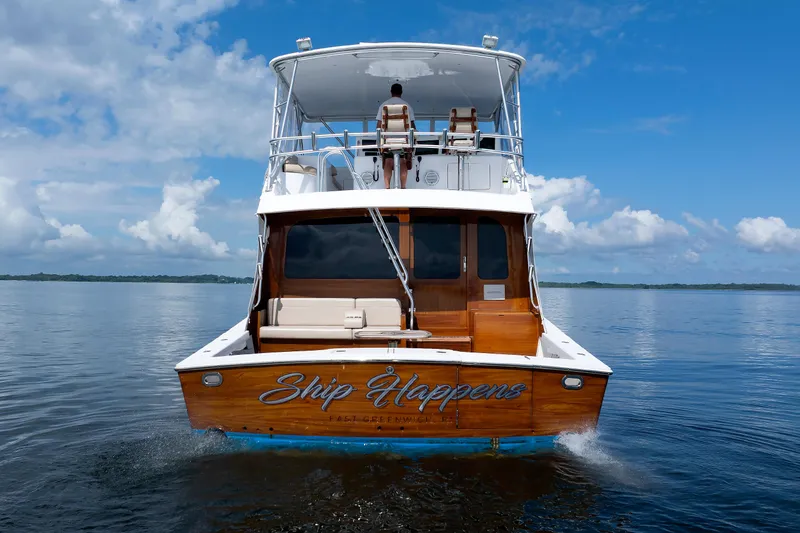 Slide: The Image of Rear view of a 2002 Post Convertible 56 yacht named "Ship Happens" on calm water. - 23