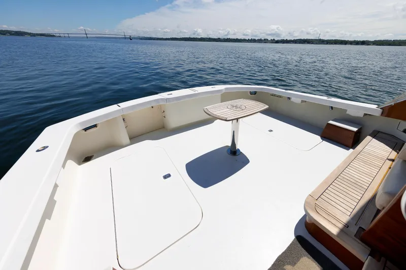 Slide: The Image of Spacious deck of 2002 Post Convertible 56 yacht with seating and table, overlooking calm waters. - 33