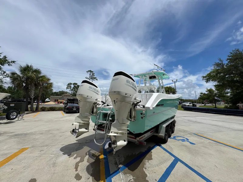 Slide: The Image of 2020 Twin Vee 310 CC GF boat with dual Suzuki outboard motors in a parking lot. - 15