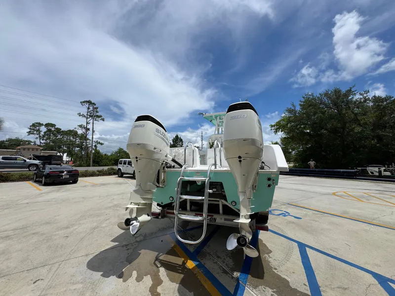 Slide: The Image of 2020 Twin Vee 310 CC GF boat with dual Suzuki outboard motors in a parking lot. - 16