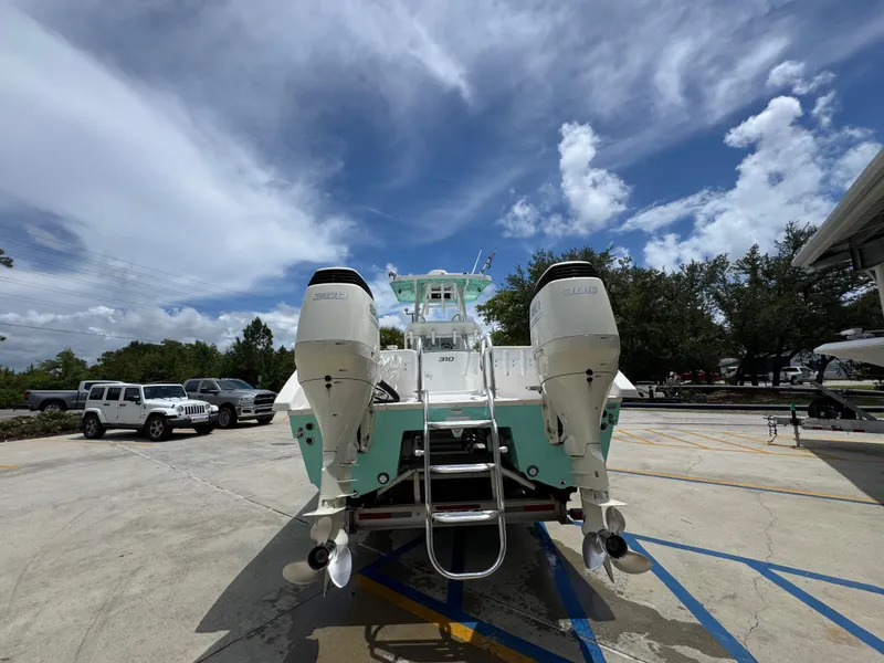 Slide: The Image of 2020 Twin Vee 310 CC GF boat with dual engines, parked outdoors under a cloudy sky. - 17