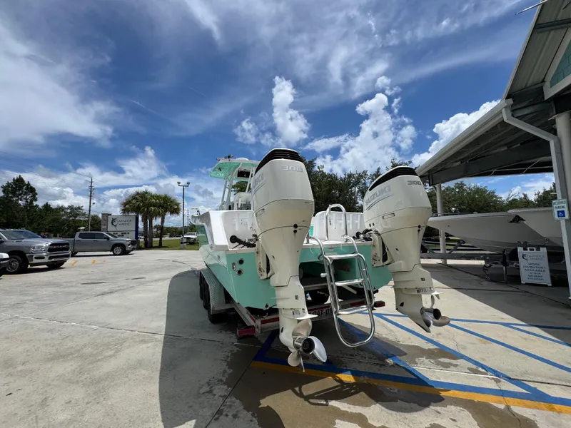 Slide: The Image of 2020 Twin Vee 310 CC GF boat with dual outboard engines in a parking lot. - 18