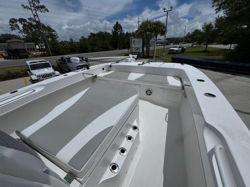 Slide: The Image of 2020 Twin Vee 310 CC GF boat interior with seating and storage, parked outdoors. - 21