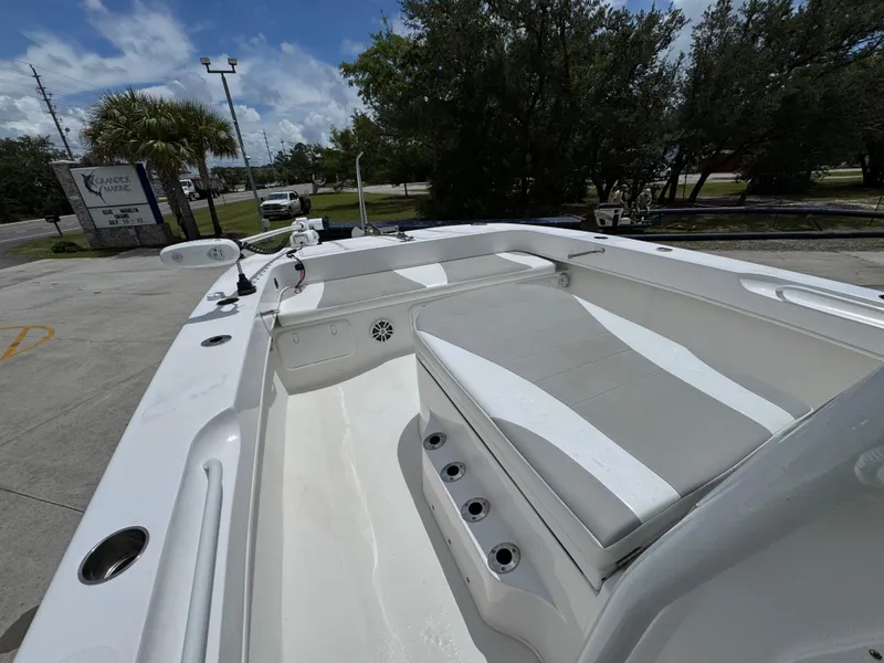 Slide: The Image of 2020 Twin Vee 310 CC GF boat interior with seating, docked outdoors. - 23