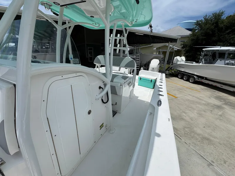 Slide: The Image of 2020 Twin Vee 310 CC GF boat interior with seating and storage, docked outdoors. - 28