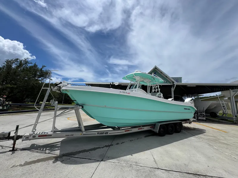 Slide: The Image of 2020 Twin Vee 310 CC GF boat on trailer under a cloudy sky. - 3