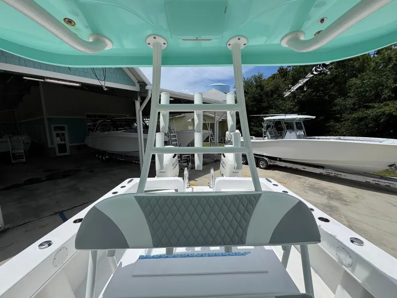 Slide: The Image of 2020 Twin Vee 310 CC GF boat interior with teal accents and outdoor storage setting. - 32