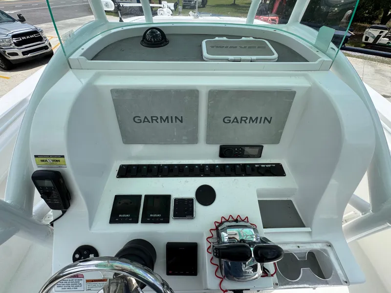 Slide: The Image of 2020 Twin Vee 310 CC GF boat dashboard with Garmin navigation systems and controls. - 36